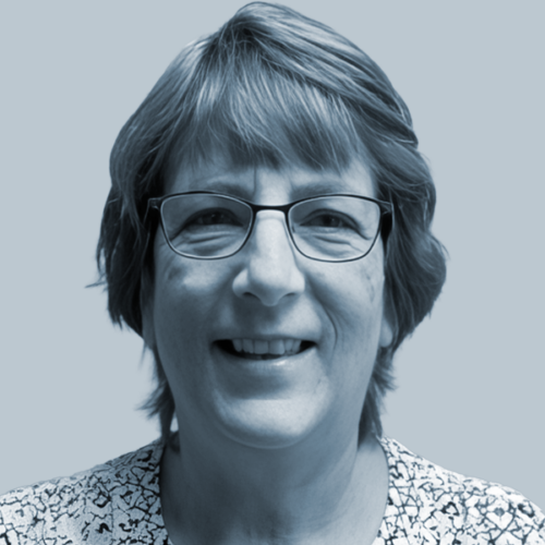 Smiling woman with short hair and glasses facing the camera